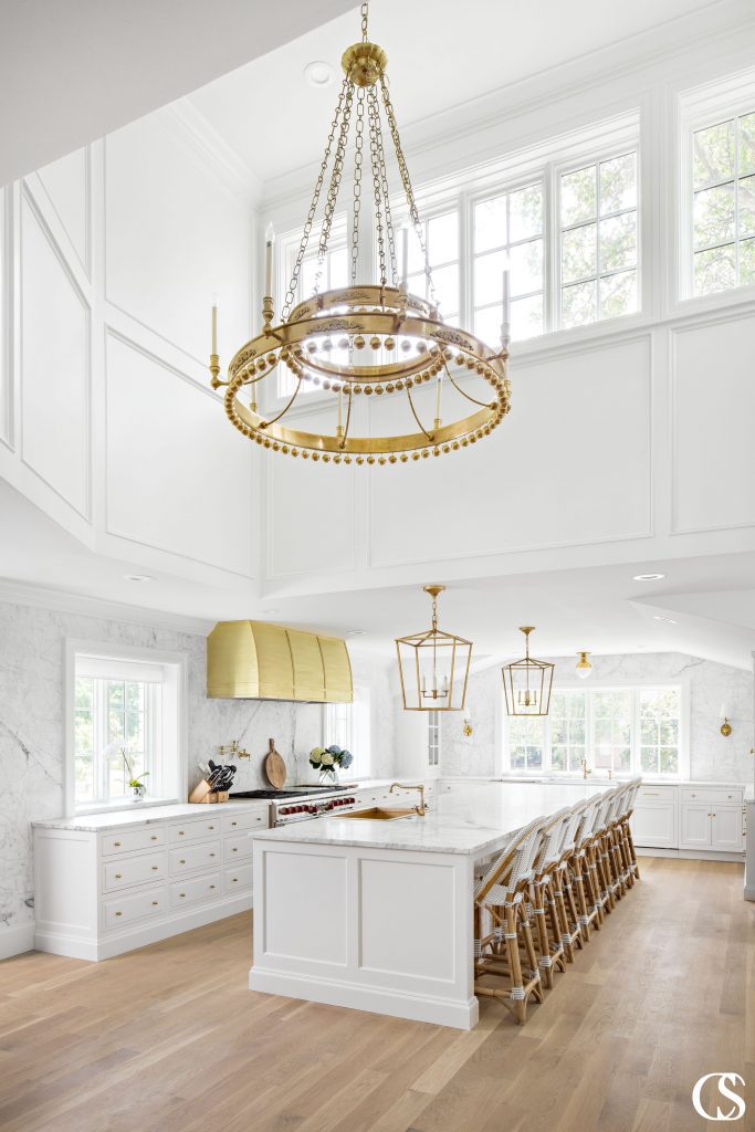 A large island is the prefect way to make the best use of the space in this custom white kitchen design. Not only does it operate as part of the kitchen triangle since it houses the sink, it also provides seating for eight guests!